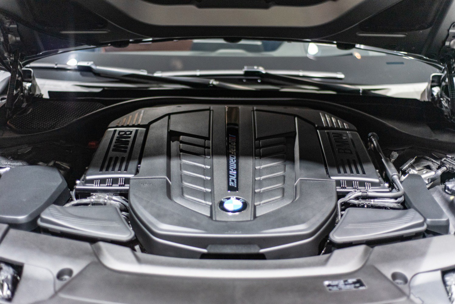 Engine compartment with BMW M Performance cover inside luxury SUV.