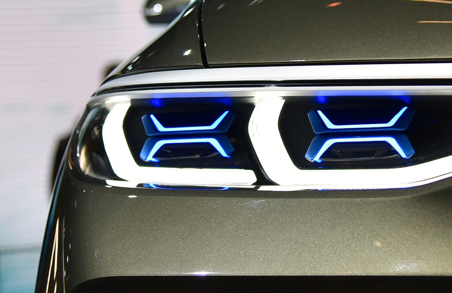 Close-up of futuristic LED headlights with blue accents and white contours.
