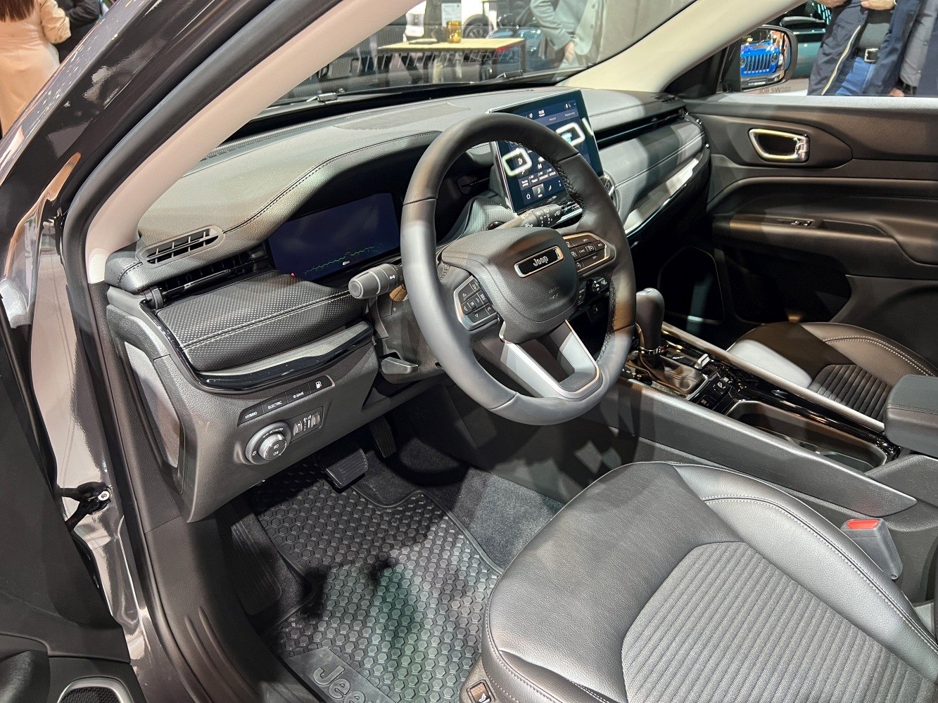 Modern vehicle interior with dashboard, steering wheel, and front seats