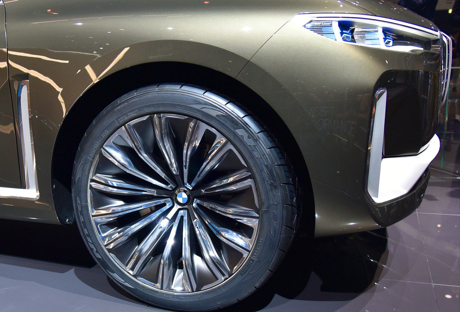 Close-up of large alloy wheel and front fender with headlight.