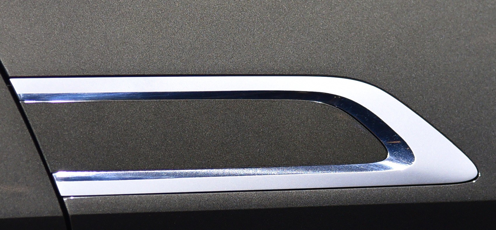 Close-up of a unique chrome trim side vent.