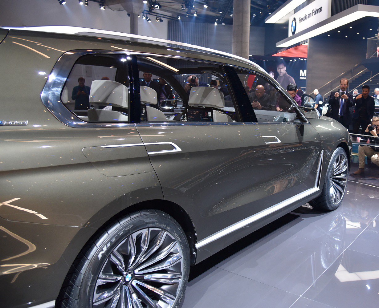 Side view of a luxury SUV with detailed alloy wheels and premium interior seating.