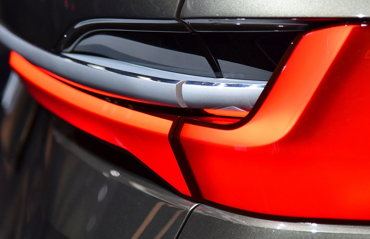 Close-up of futuristic rear light design with sharp lines and bright red illumination.