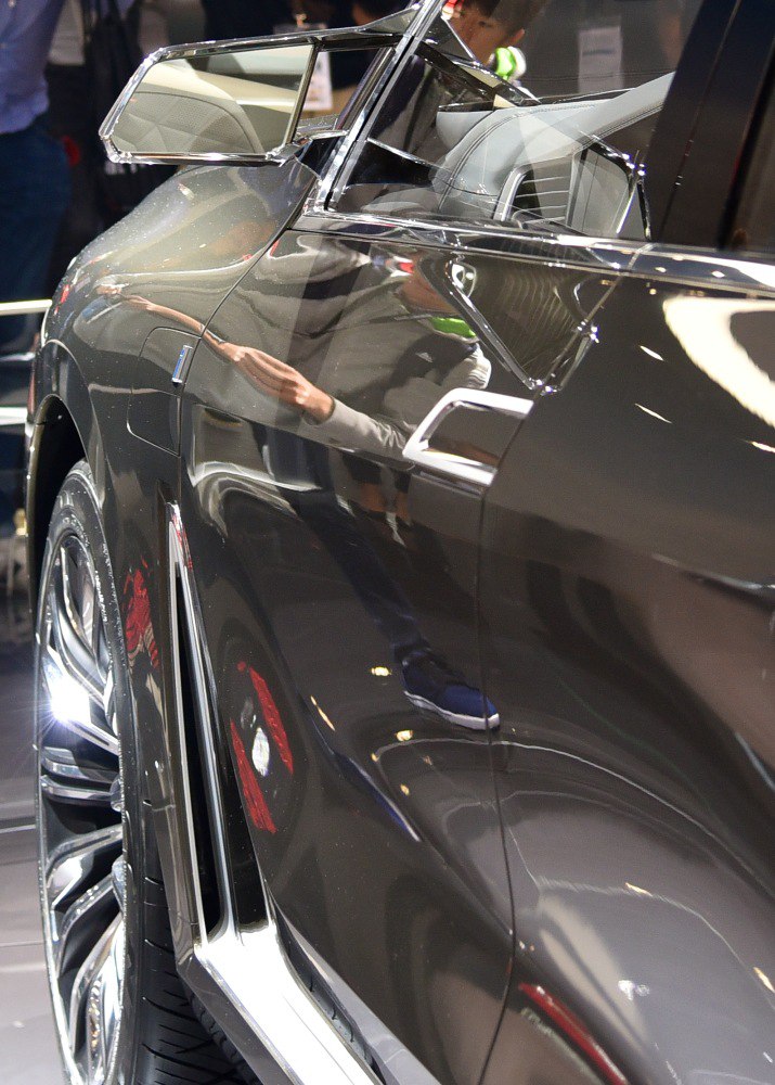 Close-up of side mirror and wheel of a luxury SUV concept car.