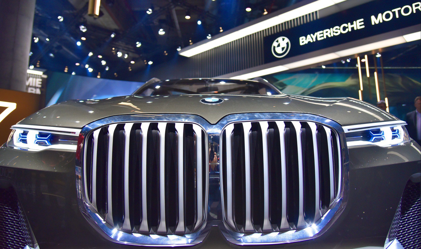 Bold kidney grille and futuristic LED headlights illuminated on an SUV front.