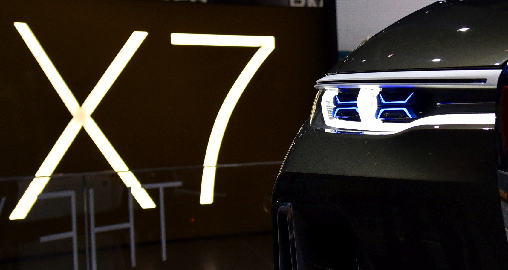 Close-up of front blue LED headlights with sleek grille