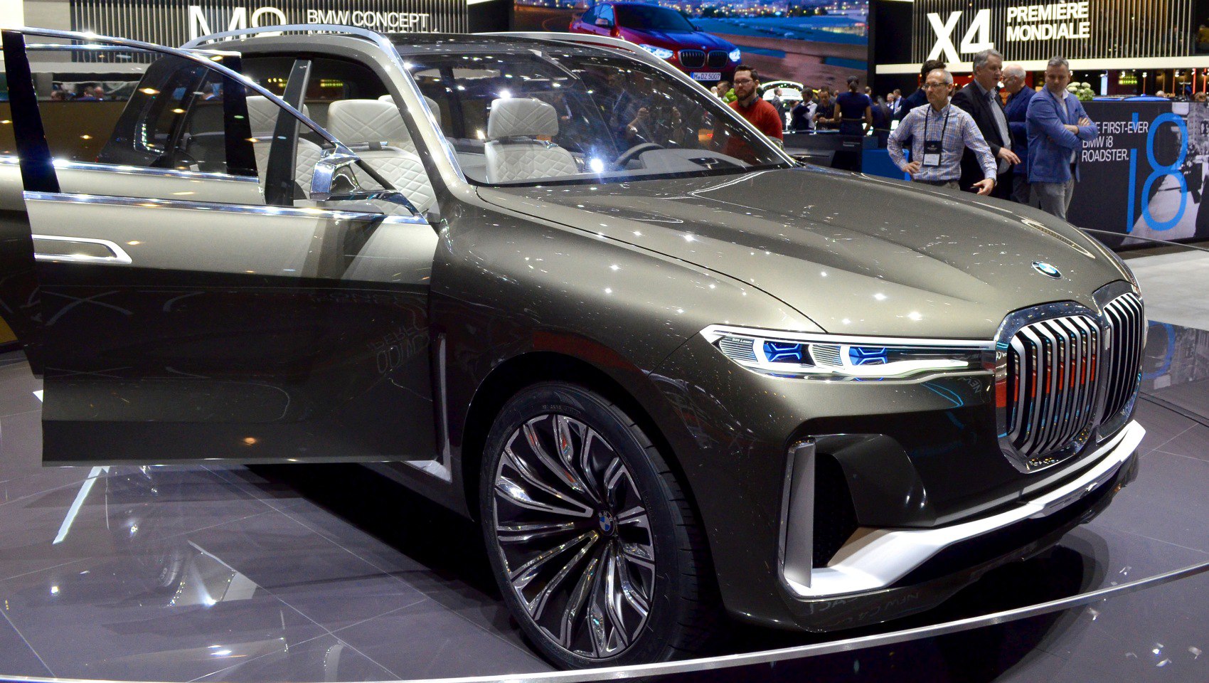 Large kidney grille and futuristic LED headlights with open driver door.