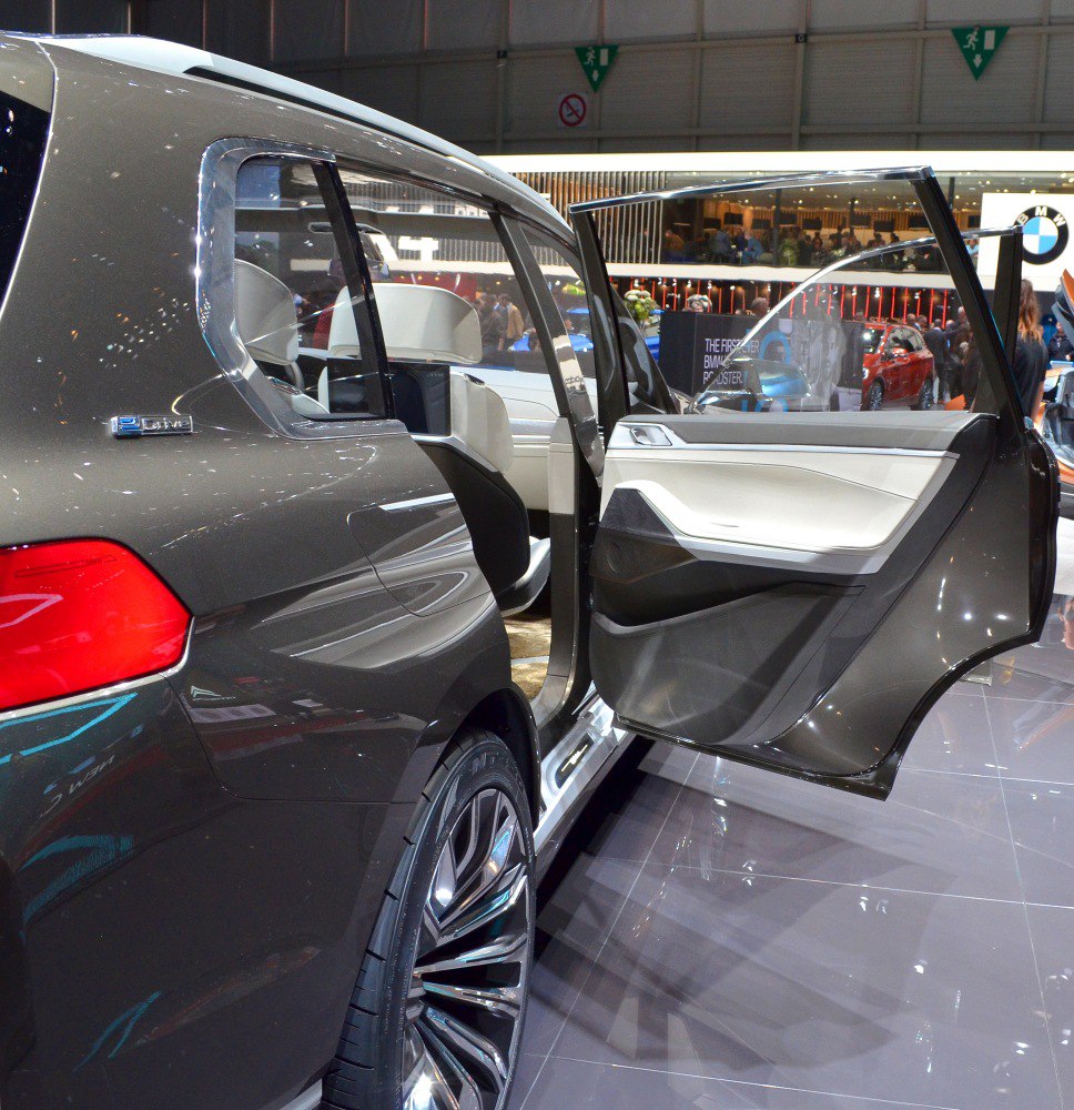 Open rear door with visible interior leather seats and alloy wheel