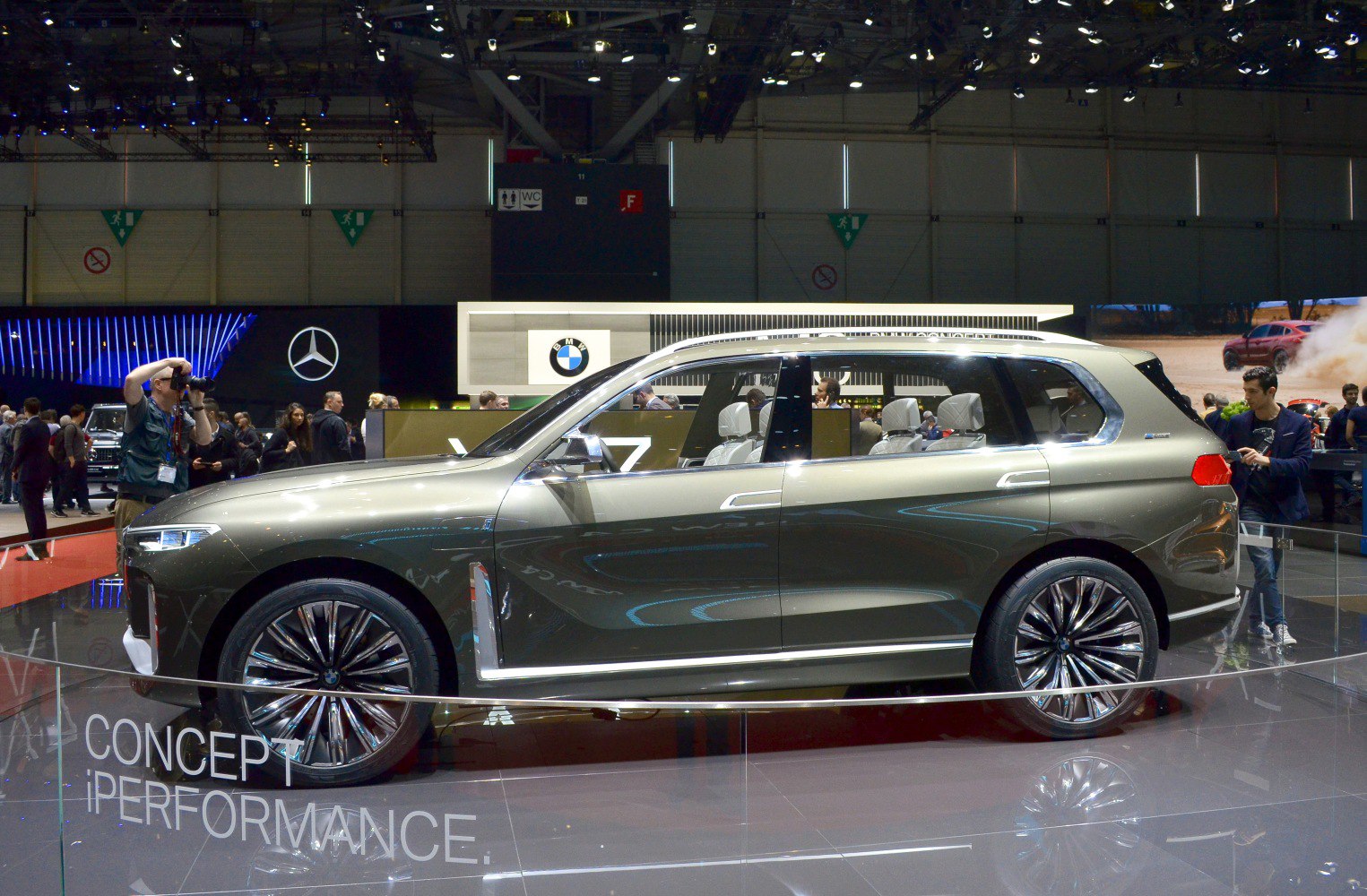 Sleek SUV side profile with futuristic large alloy wheels showcased indoors