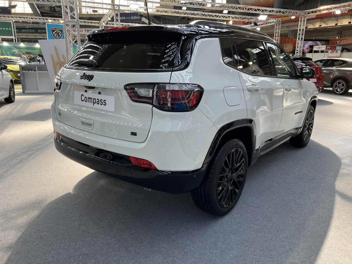 Rear and side view of white SUV with black roof and stylish alloy wheels