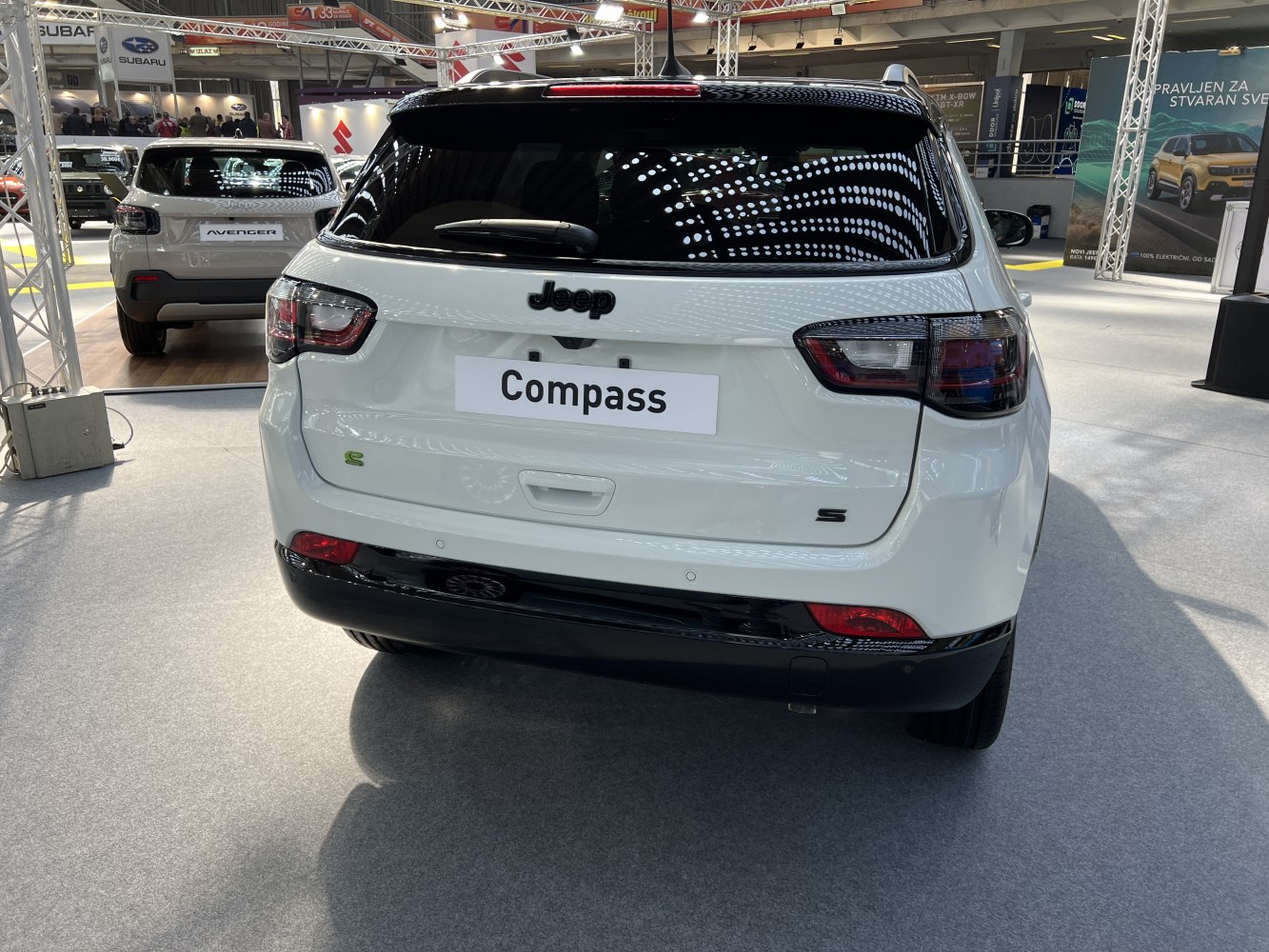 Rear view of white SUV with distinctive tail lights and black trim.