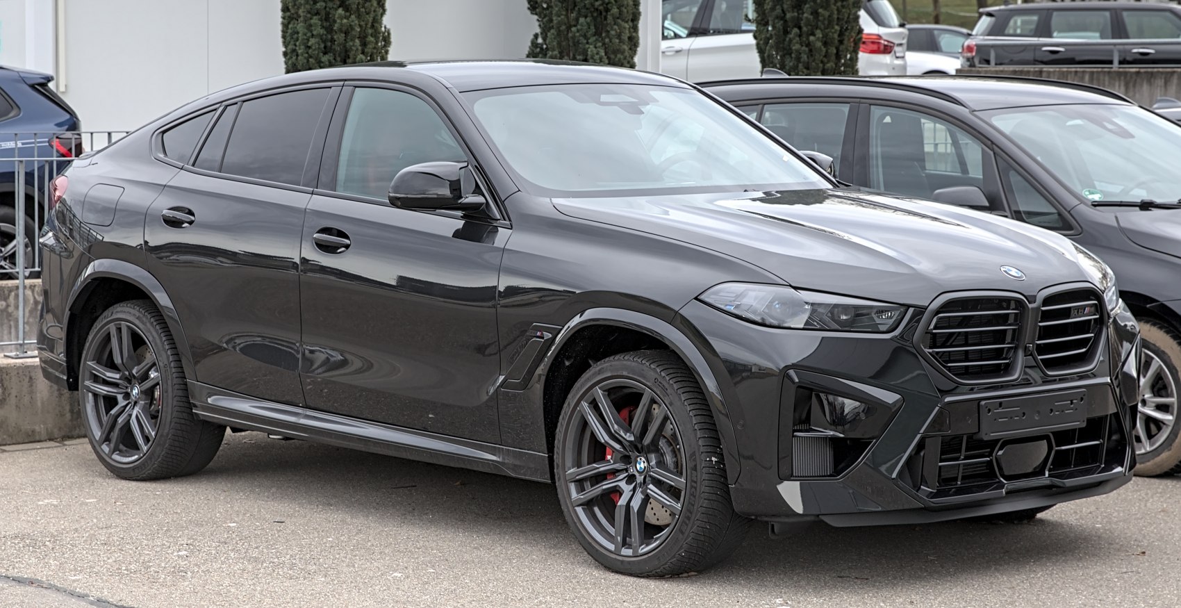 Front side view of a sleek black SUV with aggressive grille and sporty wheels