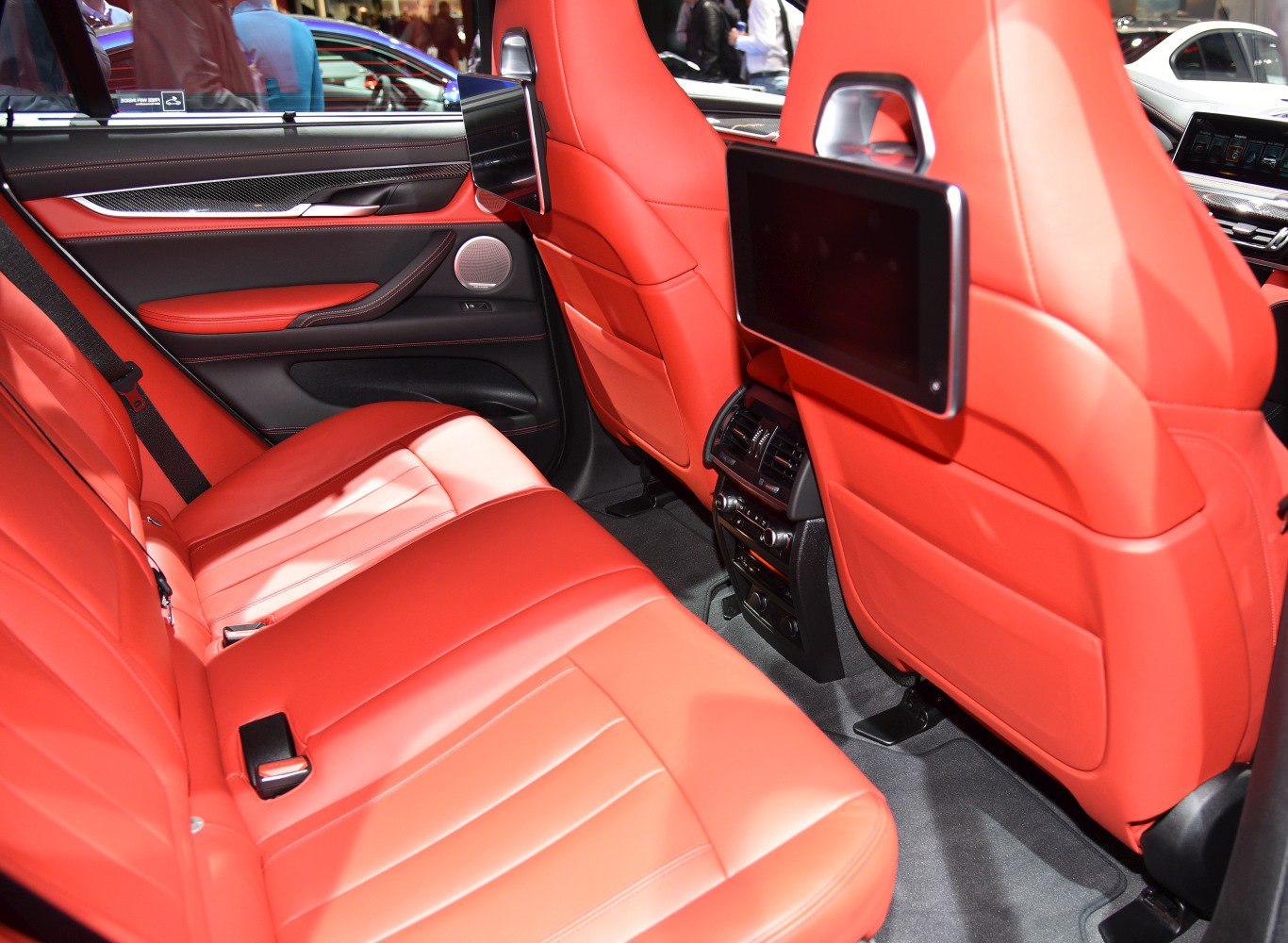 Rear passenger seating with red leather and dual entertainment screens