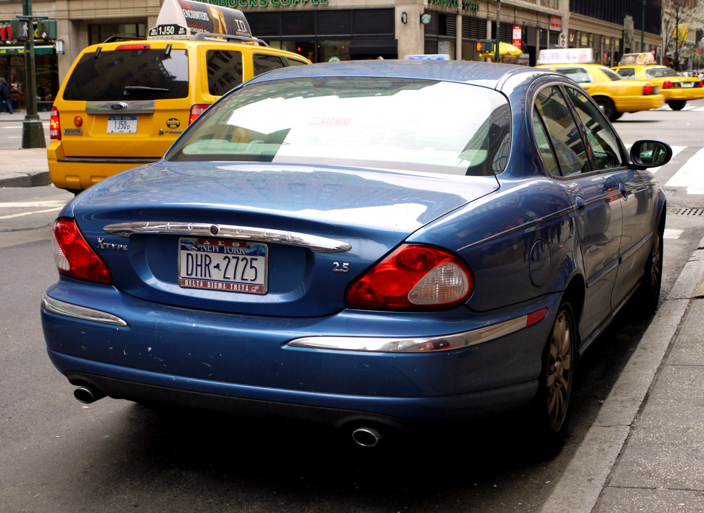 Rear view of sedan with dual exhaust and rounded taillights