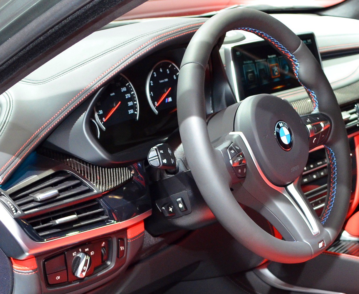 Steering wheel, instrument cluster, and dashboard interior features with carbon trim and controls