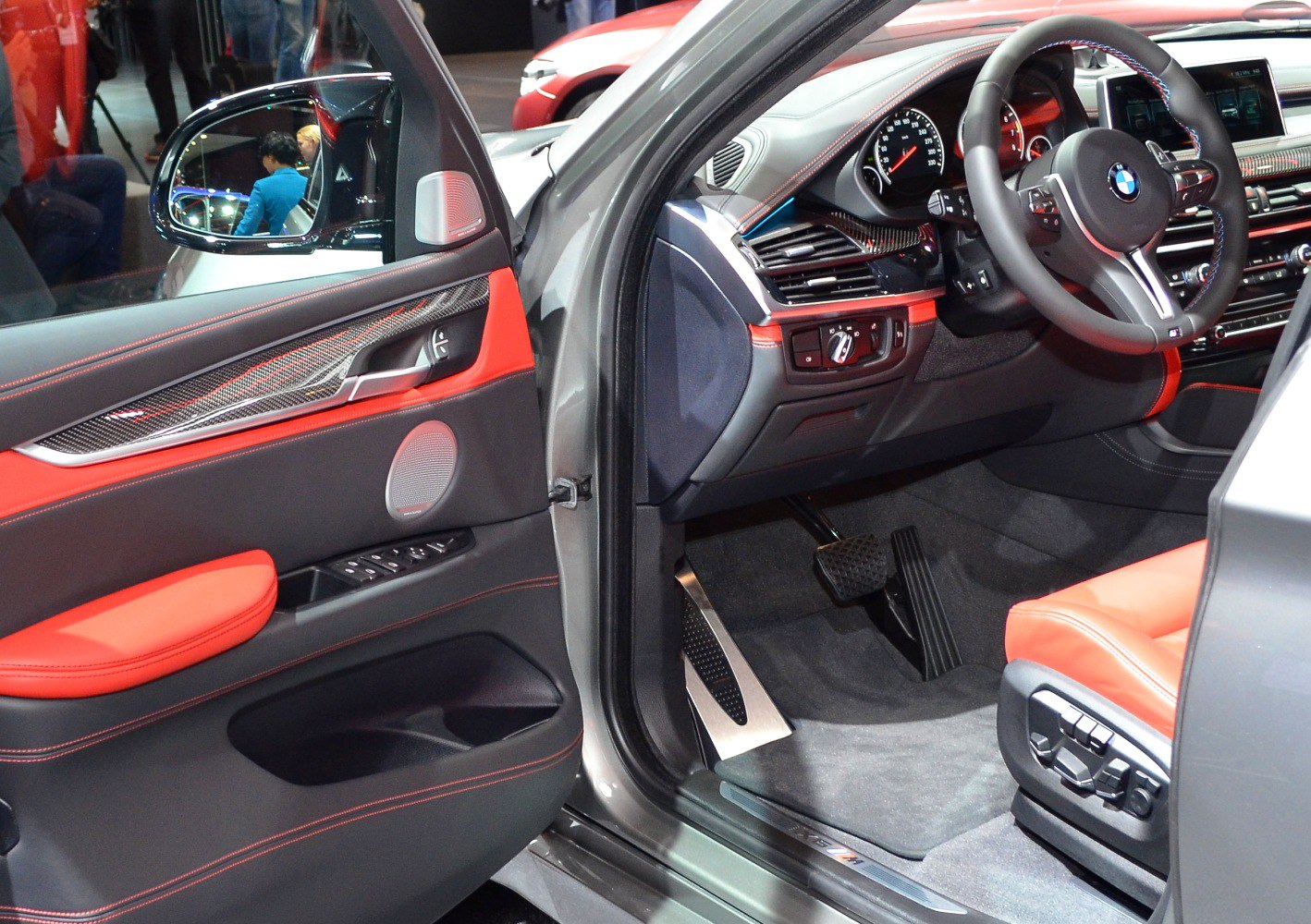 Sporty red leather interior with carbon fiber trim and detailed driver controls