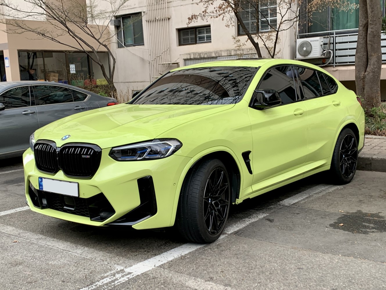 Bright yellow-green SUV with sporty black grille and wheels, aggressive front design.