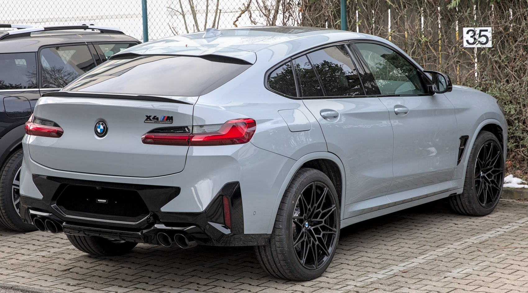 Rear and quarter view with quad exhausts, glossy black diffuser, and sleek SUV coupe design