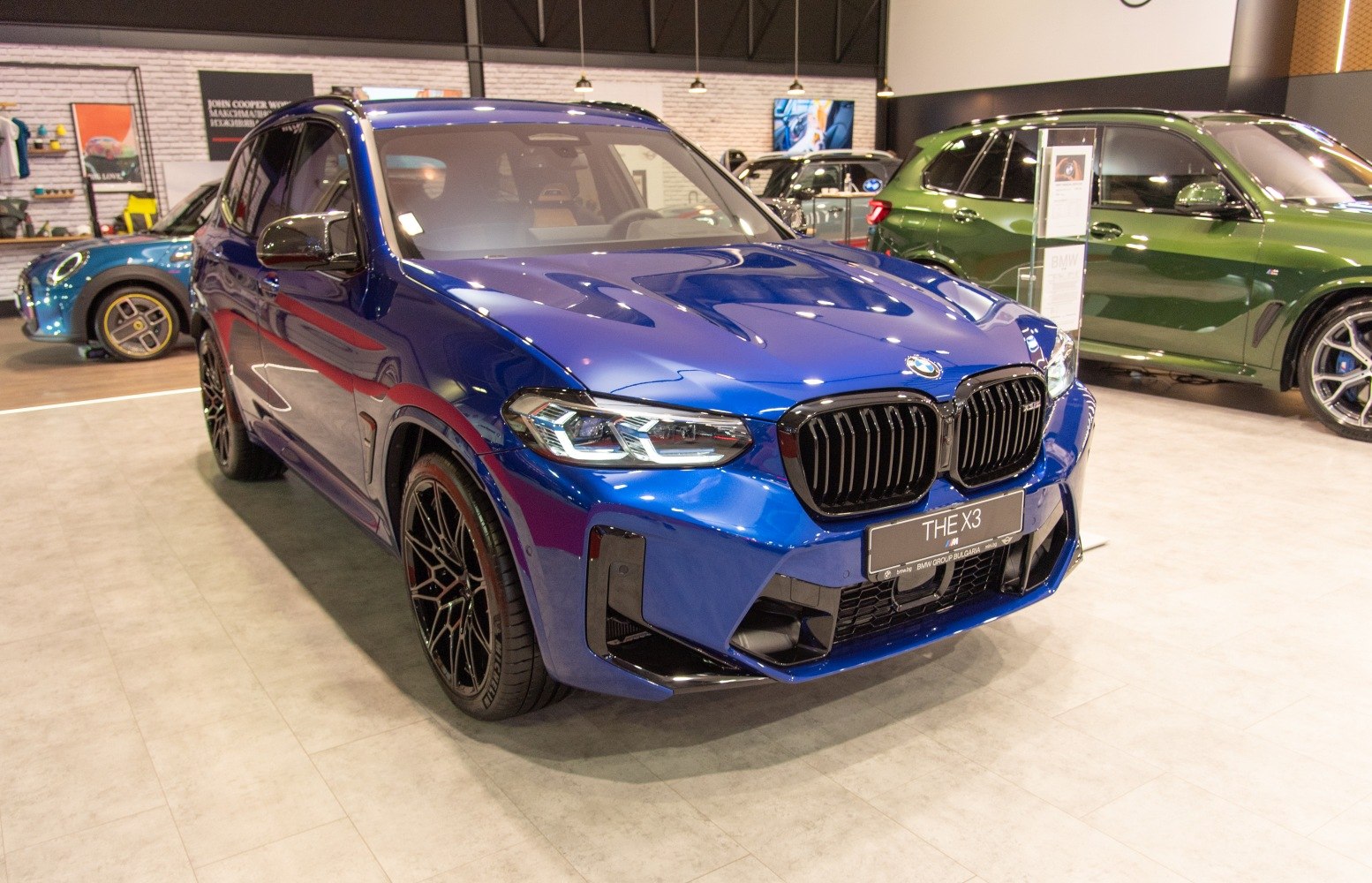 Blue SUV with black grille and alloy wheels front view indoors