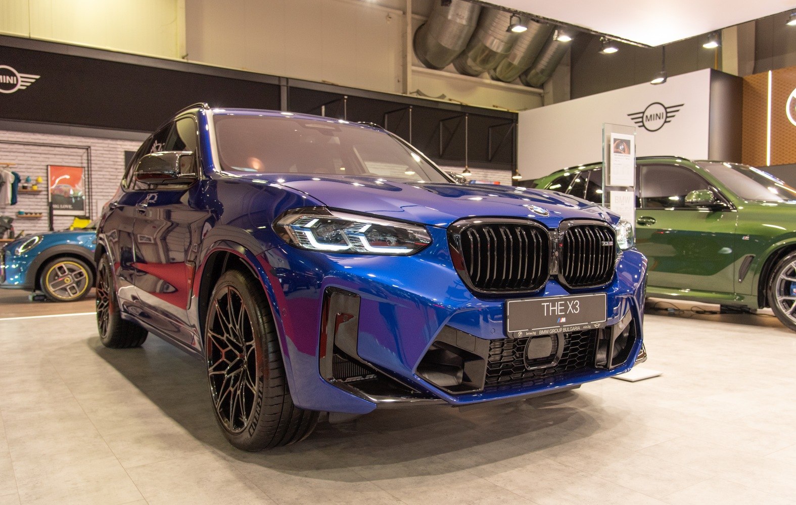 Blue SUV front with black kidney grille and LED headlights.