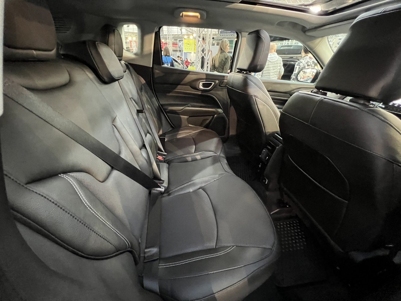 Spacious rear seats with black leather upholstery and seat belts