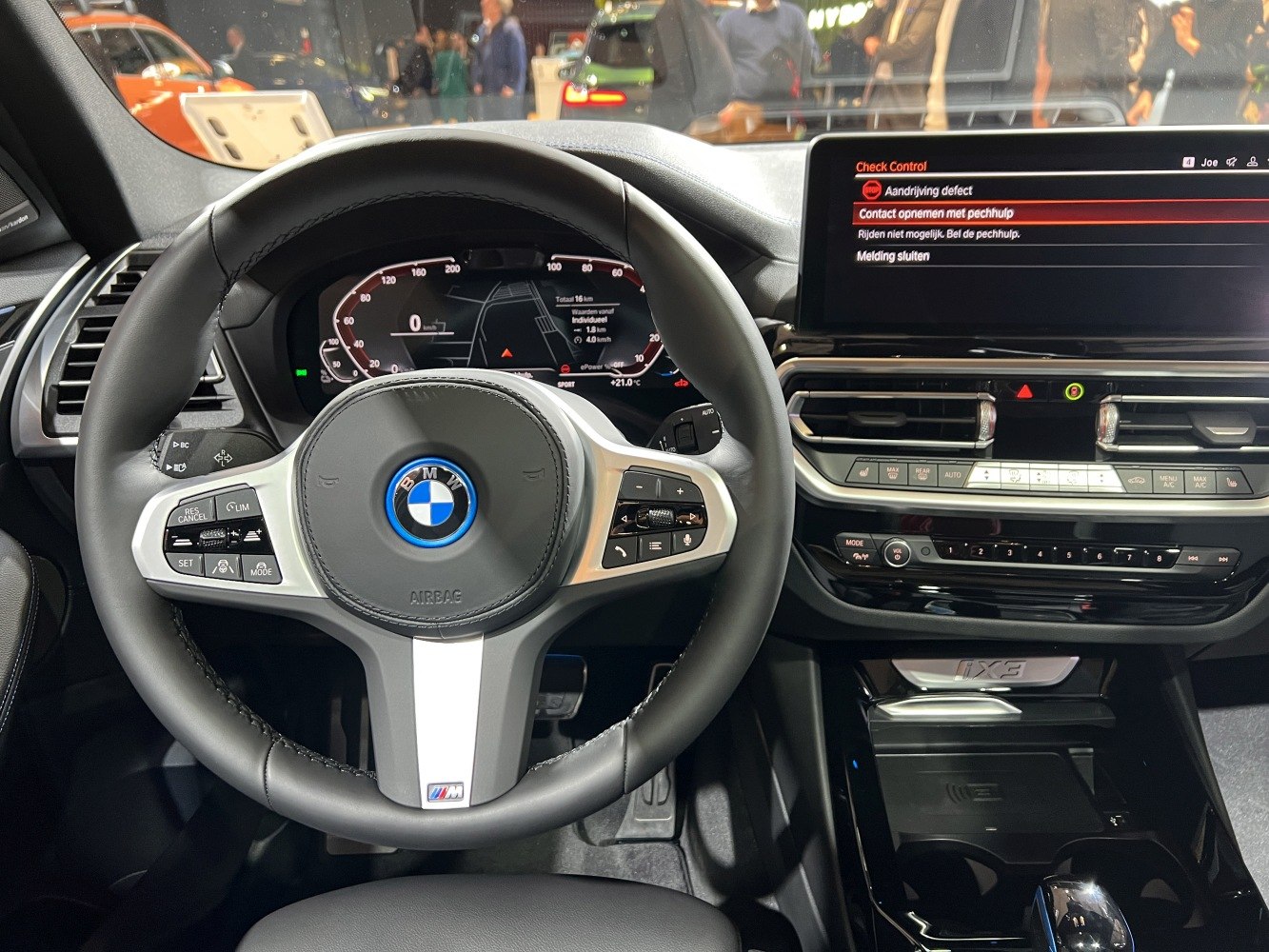 Modern BMW steering wheel with digital dashboard and control center.