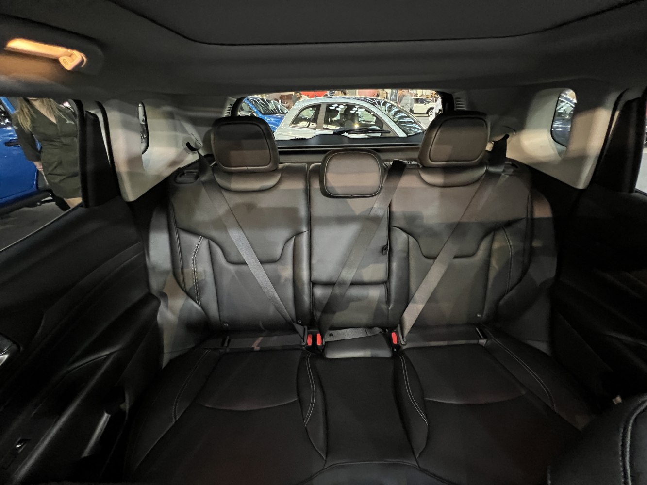 Rear seating with three black leather seats and visible seatbelts
