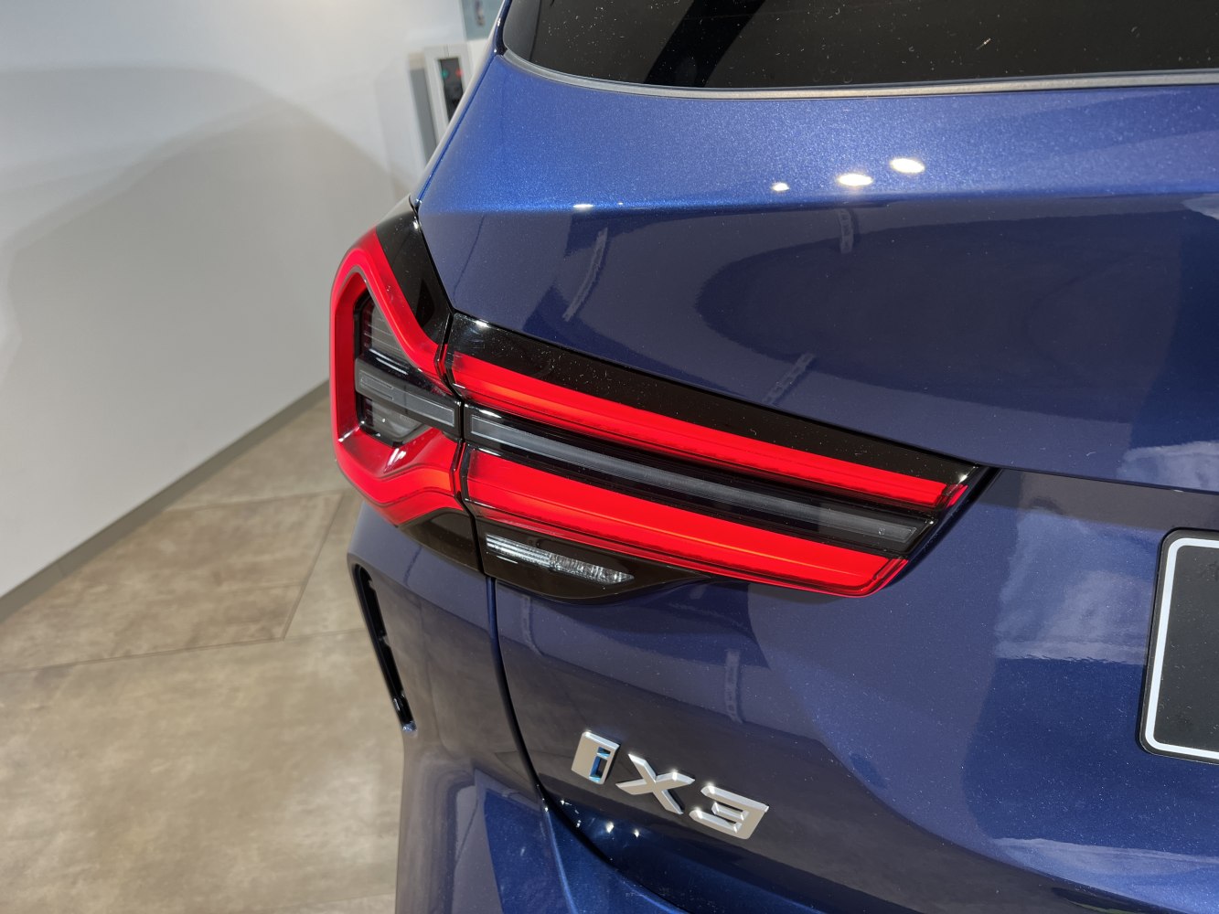 Close-up of rear LED tail lights and badge on dark blue vehicle
