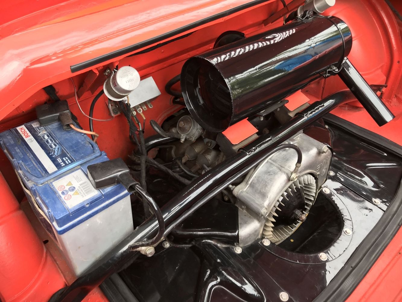 Close-up of engine compartment with battery and air intake.