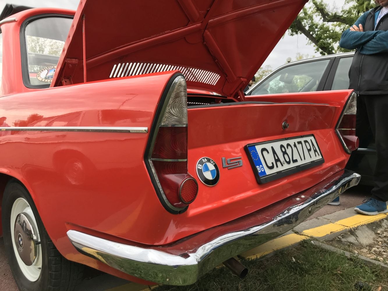 Rear view of vintage car with open engine compartment and distinctive tail lights