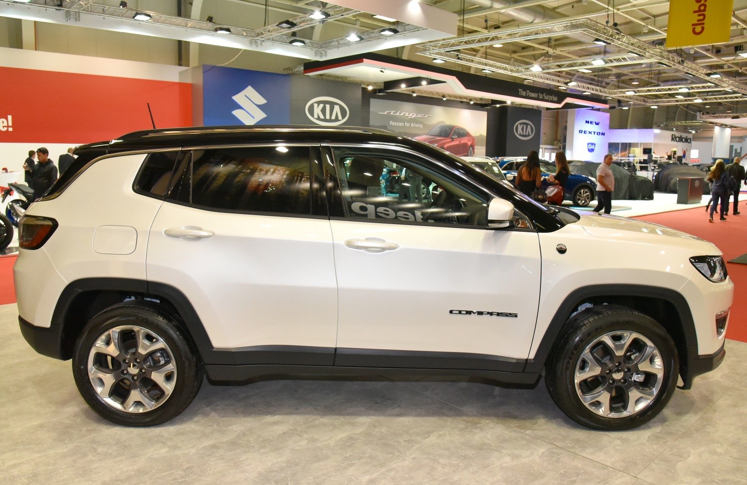 Side profile of white SUV with black roof and alloy wheels