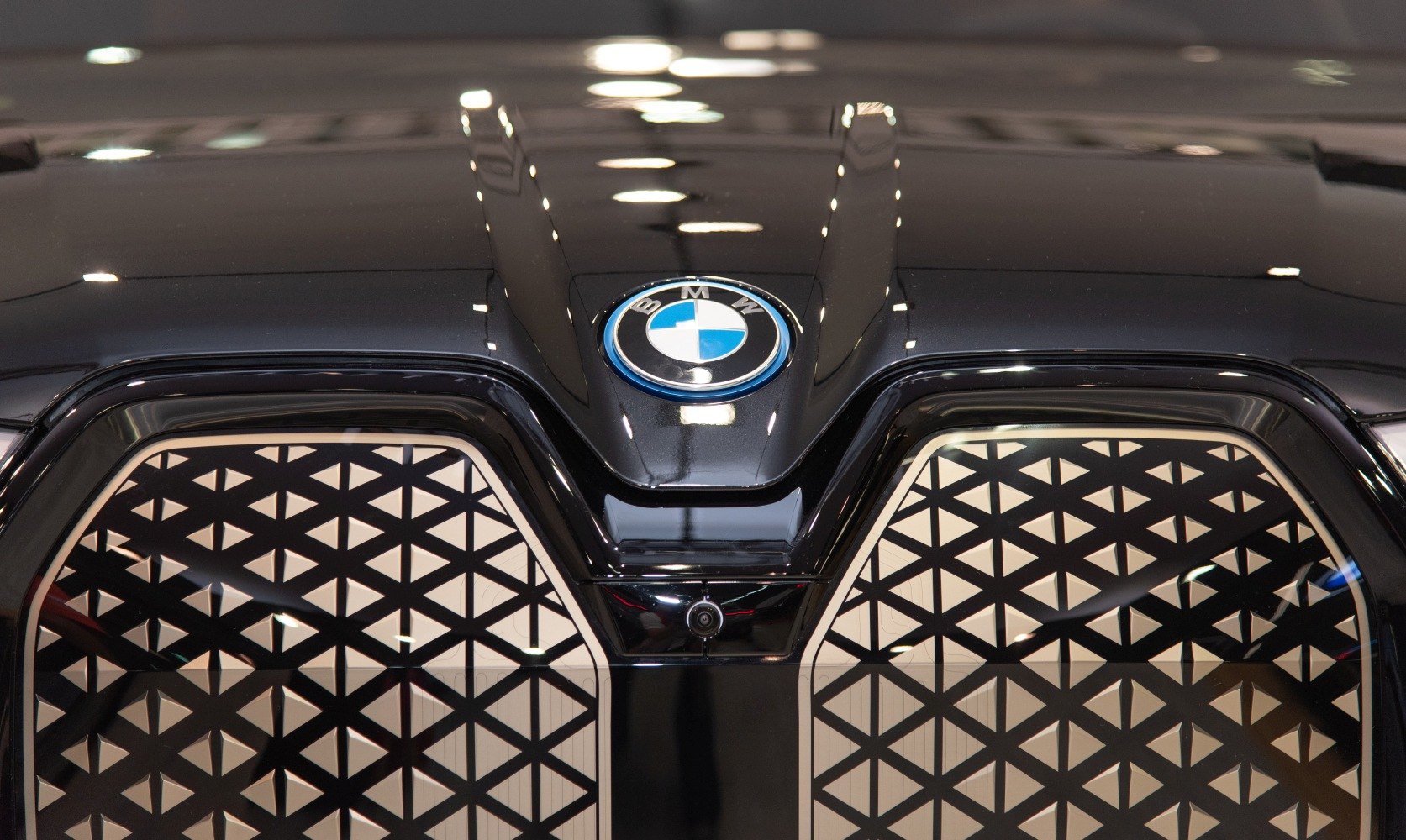 Close-up of front grille with geometric pattern, BMW logo, and front camera