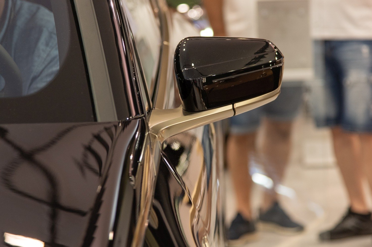 Close-up of a modern electric SUV's black side mirror with sleek design
