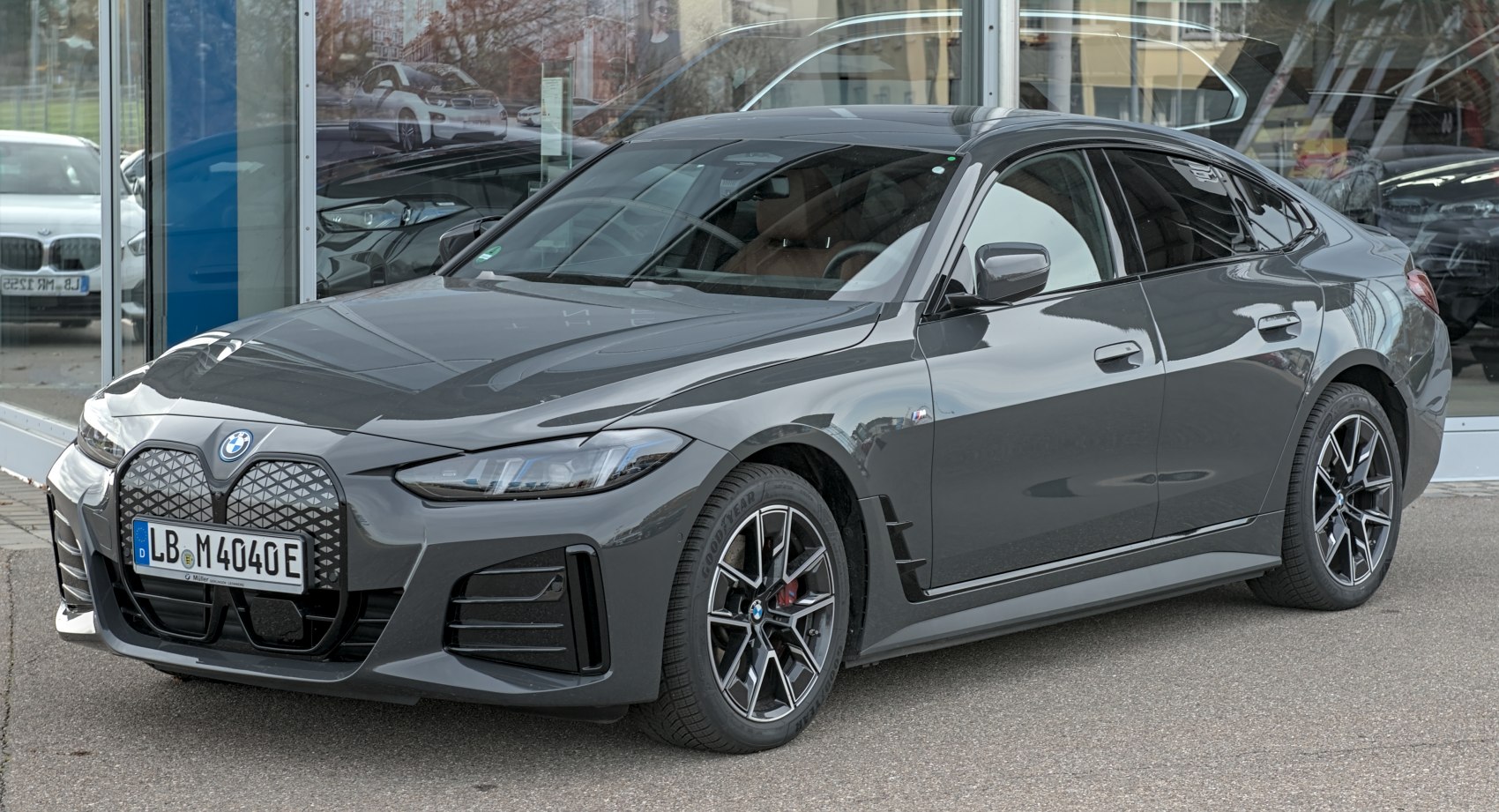 Front-side view of electric sedan with large grille and alloy wheels