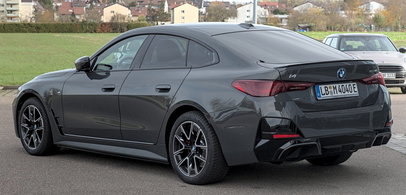 Rear-side view of a sleek electric sedan with modern wheels in dark grey.