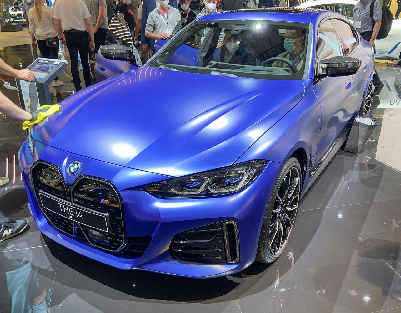 Matte blue electric sedan with large kidney grille and sleek headlights