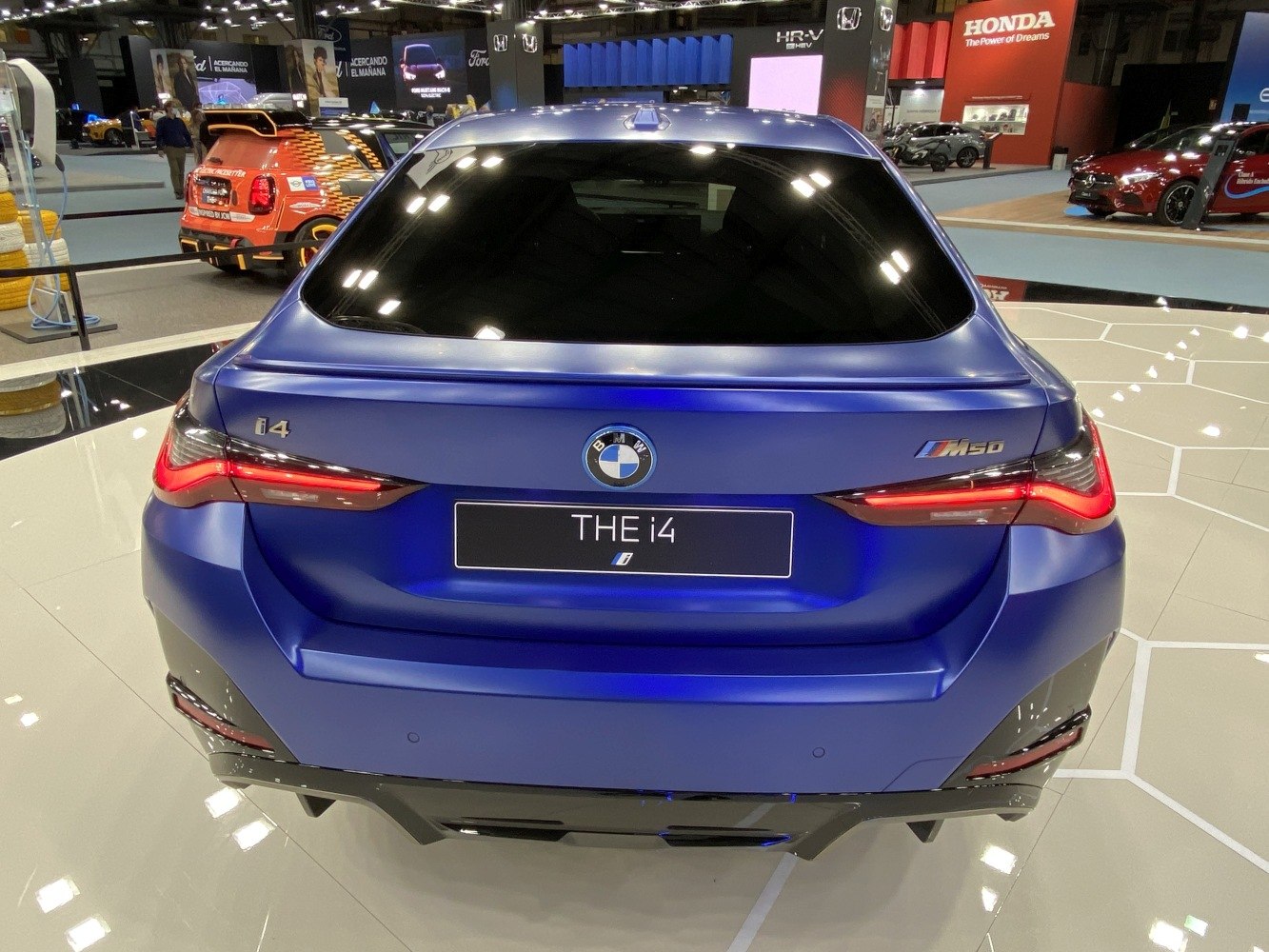 Rear view of electric sedan with sleek taillights and blue finish.