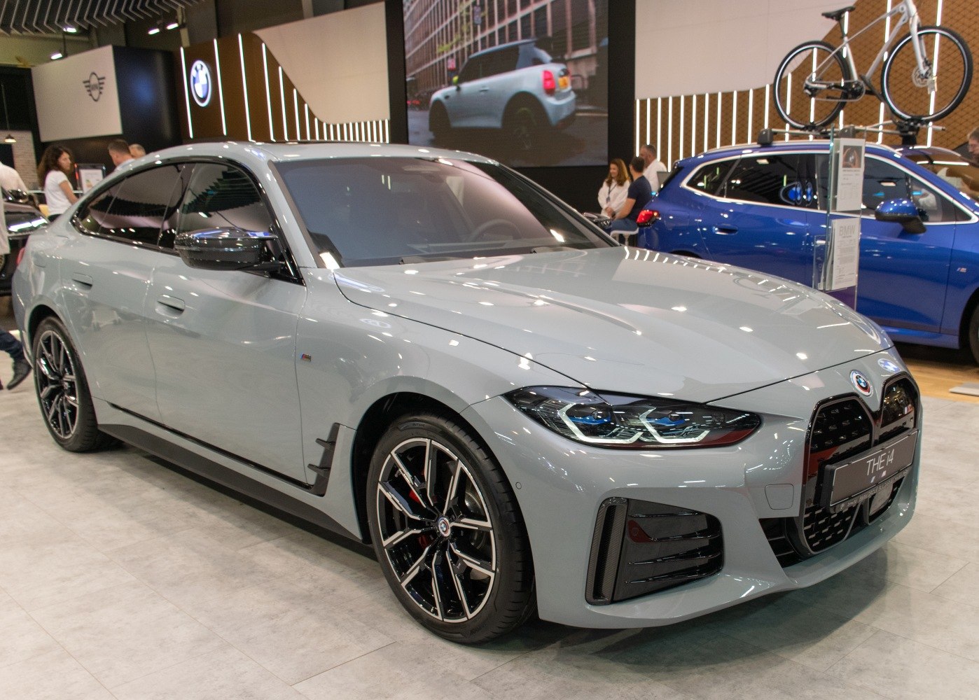 Front and side view of electric sedan with distinctive headlights and kidney grille