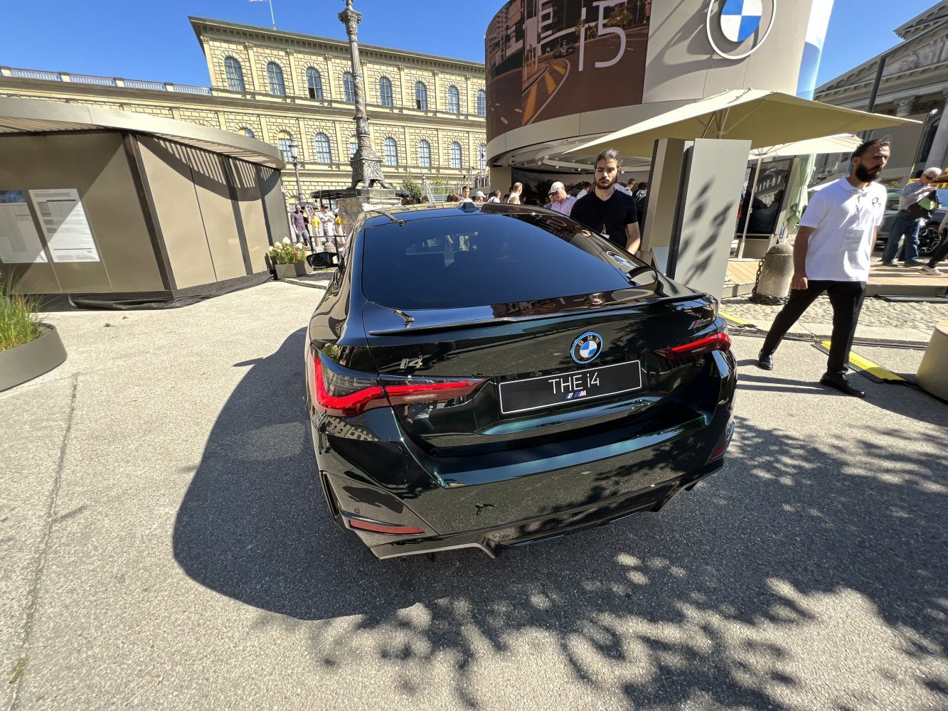 Sleek rear view of a modern electric sedan with distinctive taillights and M badge.