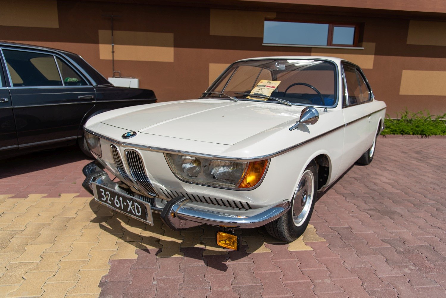 Front view of vintage coupe with classic headlights and chrome bumper