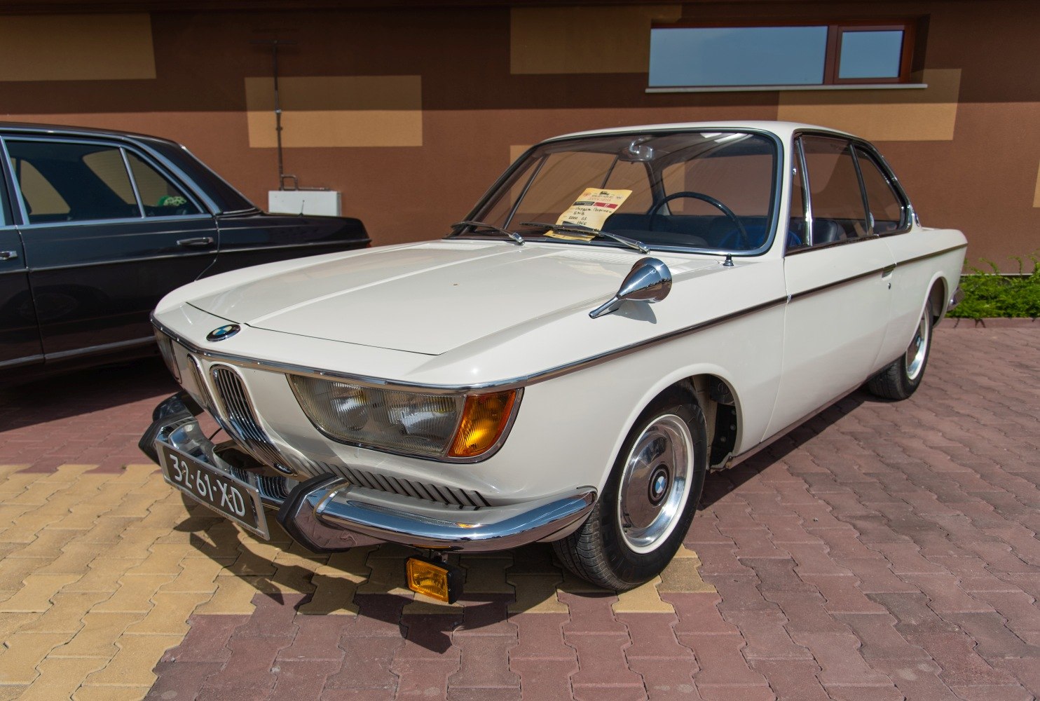 Vintage coupe front view with round headlights and chrome bumpers