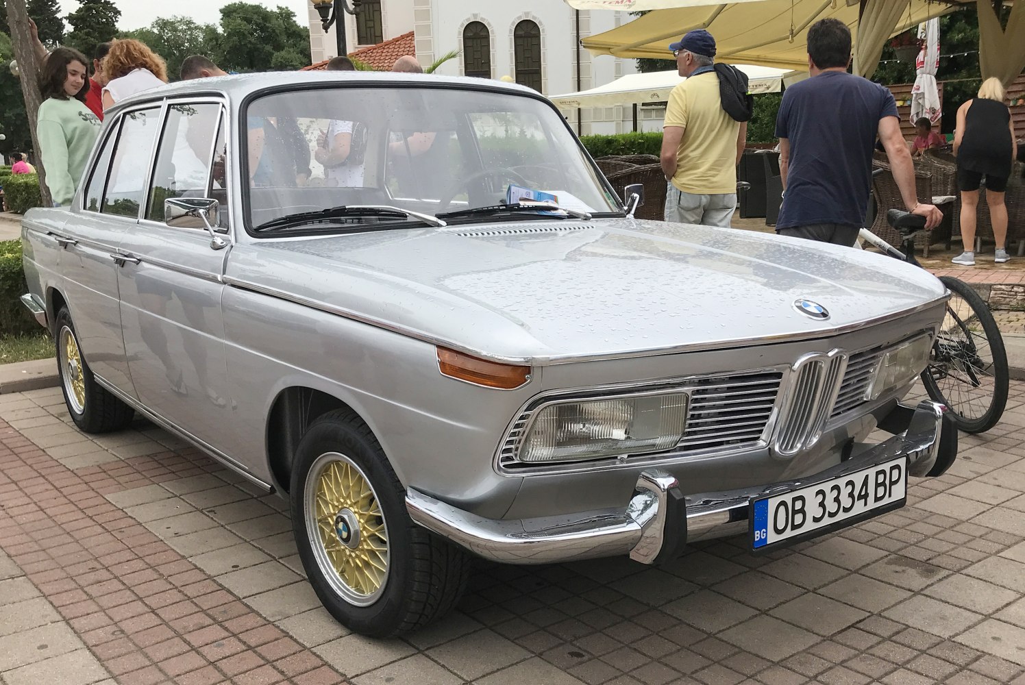 Silver vintage sedan with chrome bumpers and gold mesh wheels