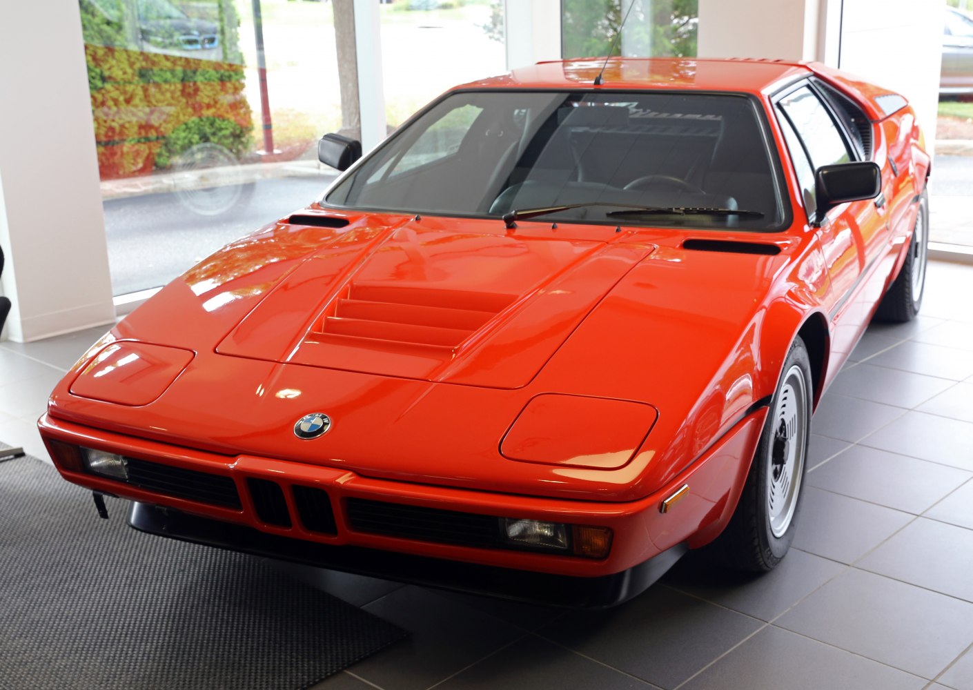 Red classic mid-engine sports car with sharp front and kidney grille