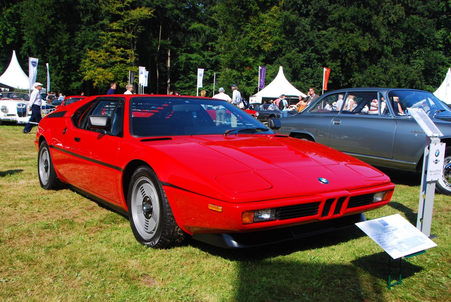 Sleek red sports coupe front with distinctive grille and wheels