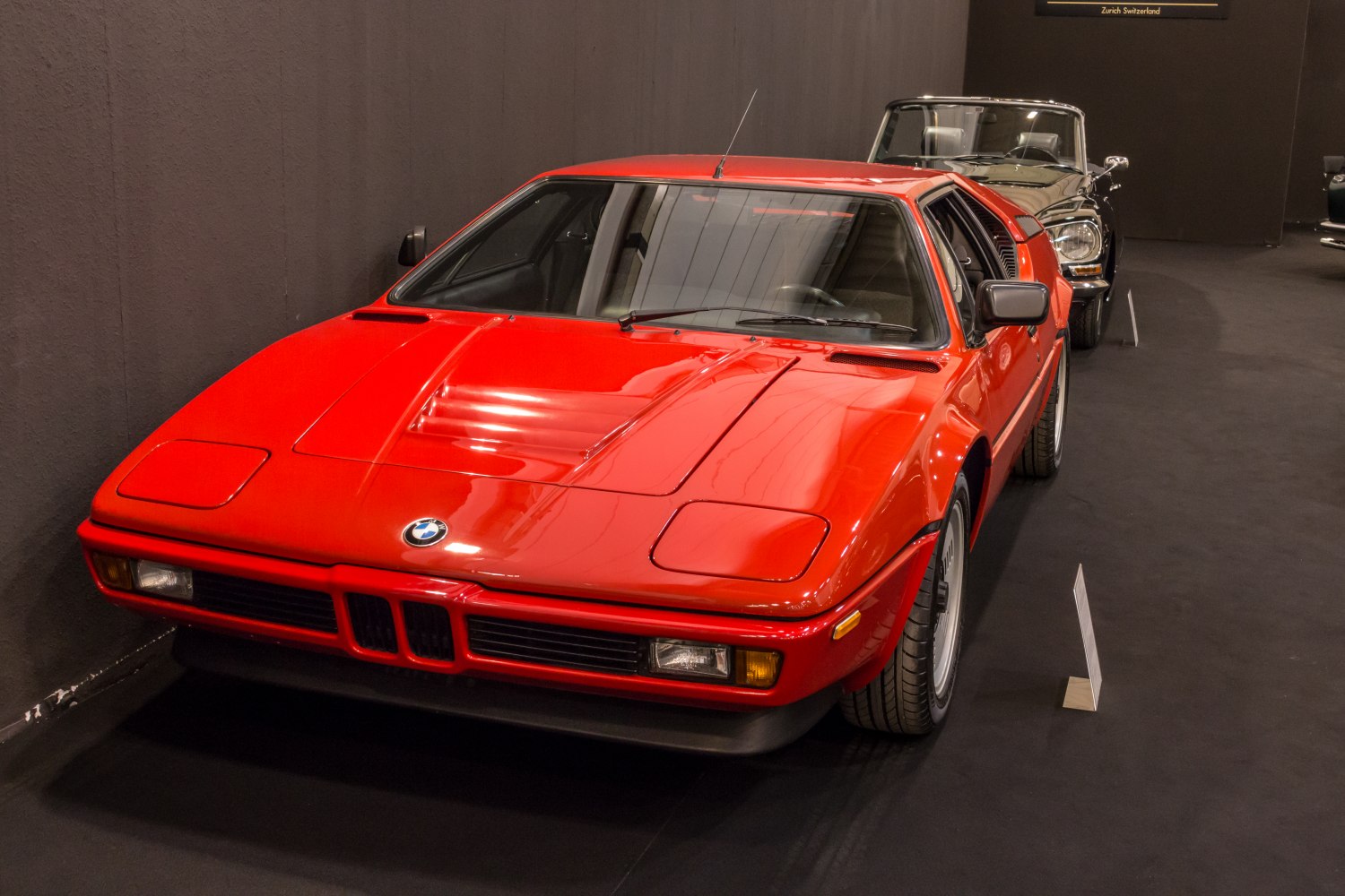 Red sports coupe with pop-up headlights and wedge-shaped hood.
