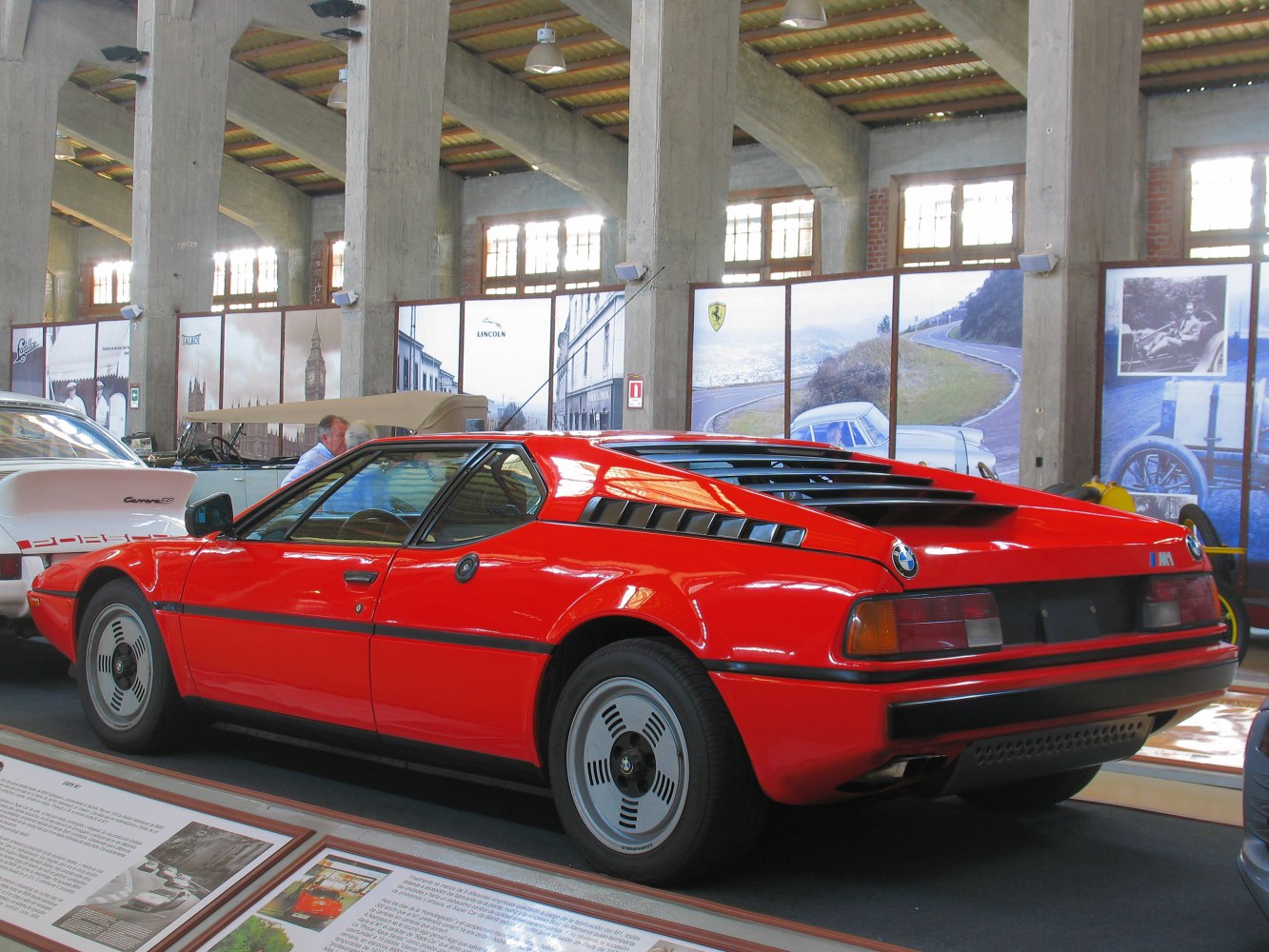 Red sports coupe rear side with distinctive vents and unique wheels