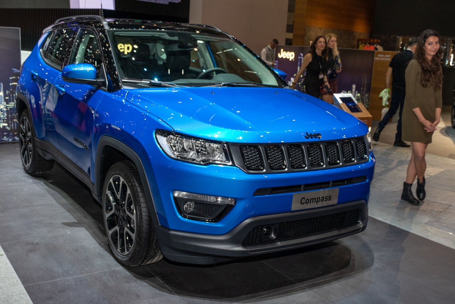 Front side view of blue SUV with signature grille and alloy wheels