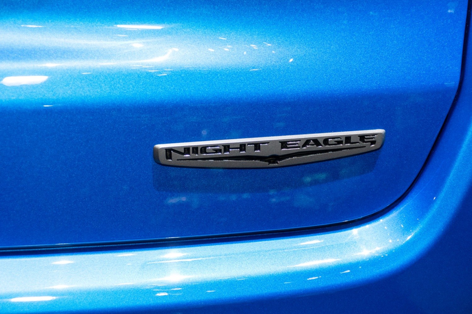 Close-up of Night Eagle badge on blue painted car surface