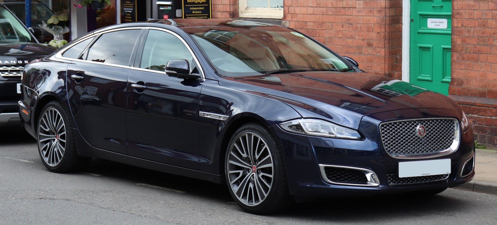 Luxury sedan with chrome mesh grille and multi-spoke alloy wheels