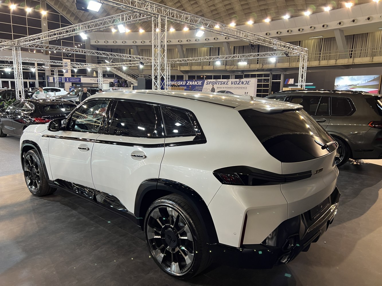 Rear side view of white SUV with black accents and large wheels